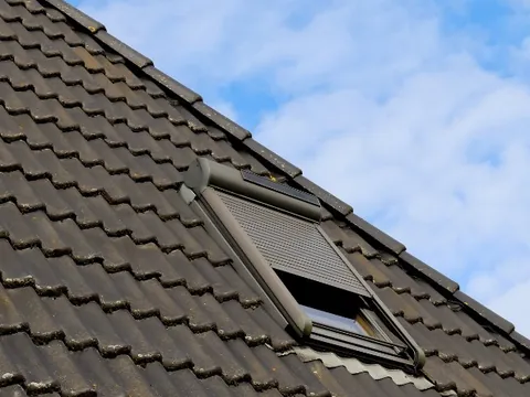 Claraboya con toldo solar integrada en una cubierta de teja aislada