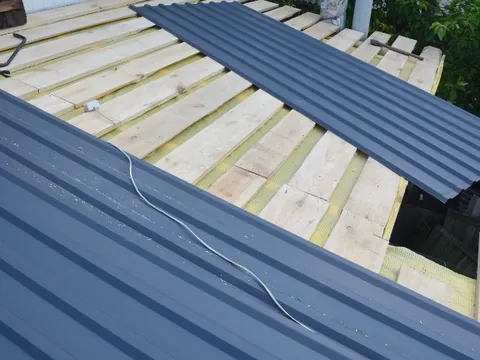 Panel metálico de cubierta colocándose sobre listones en una instalación nueva